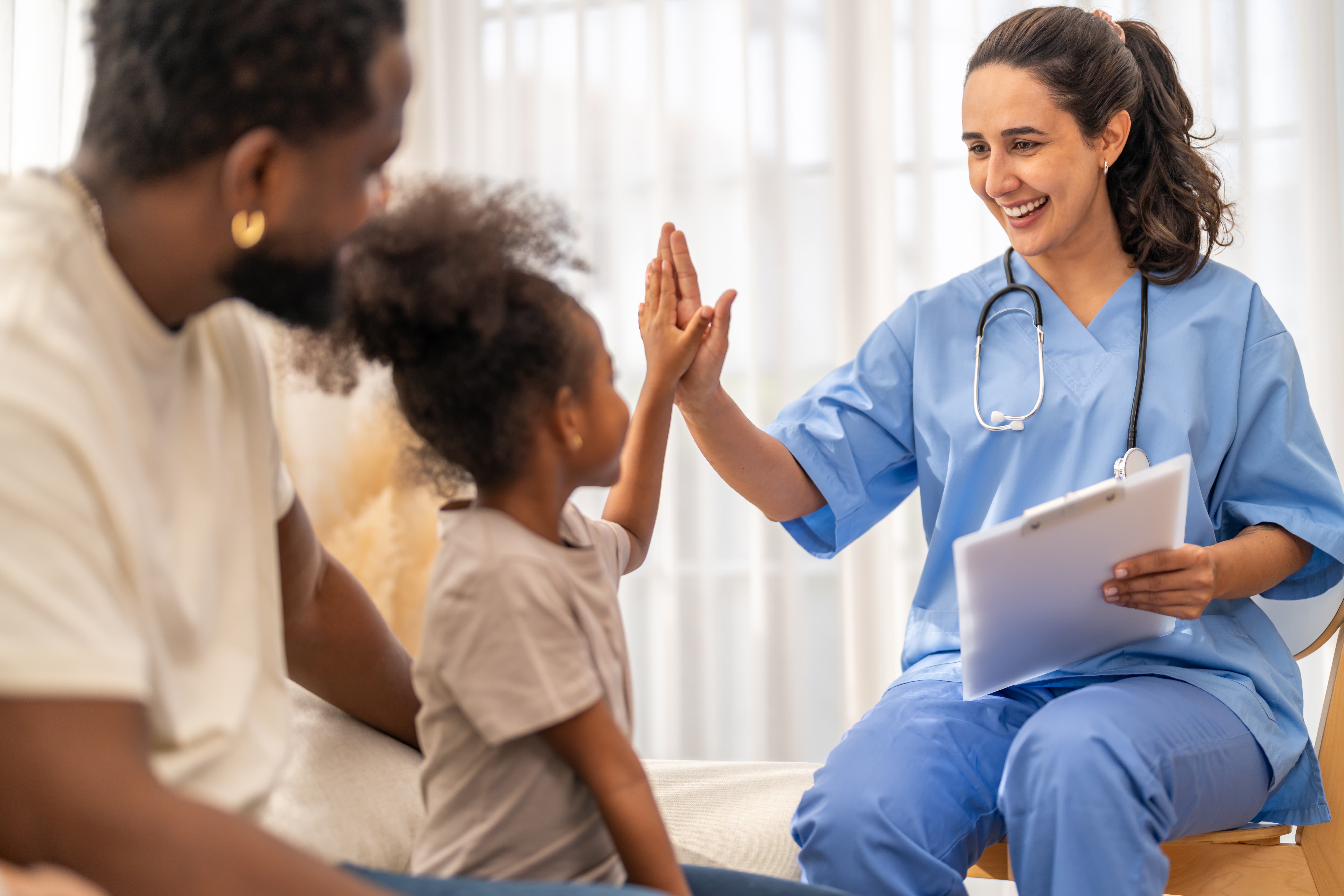 Doctor giving young patient a high five