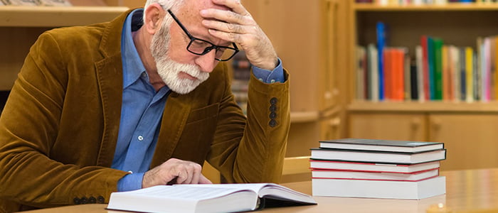 An adult studies with their textbook in a library