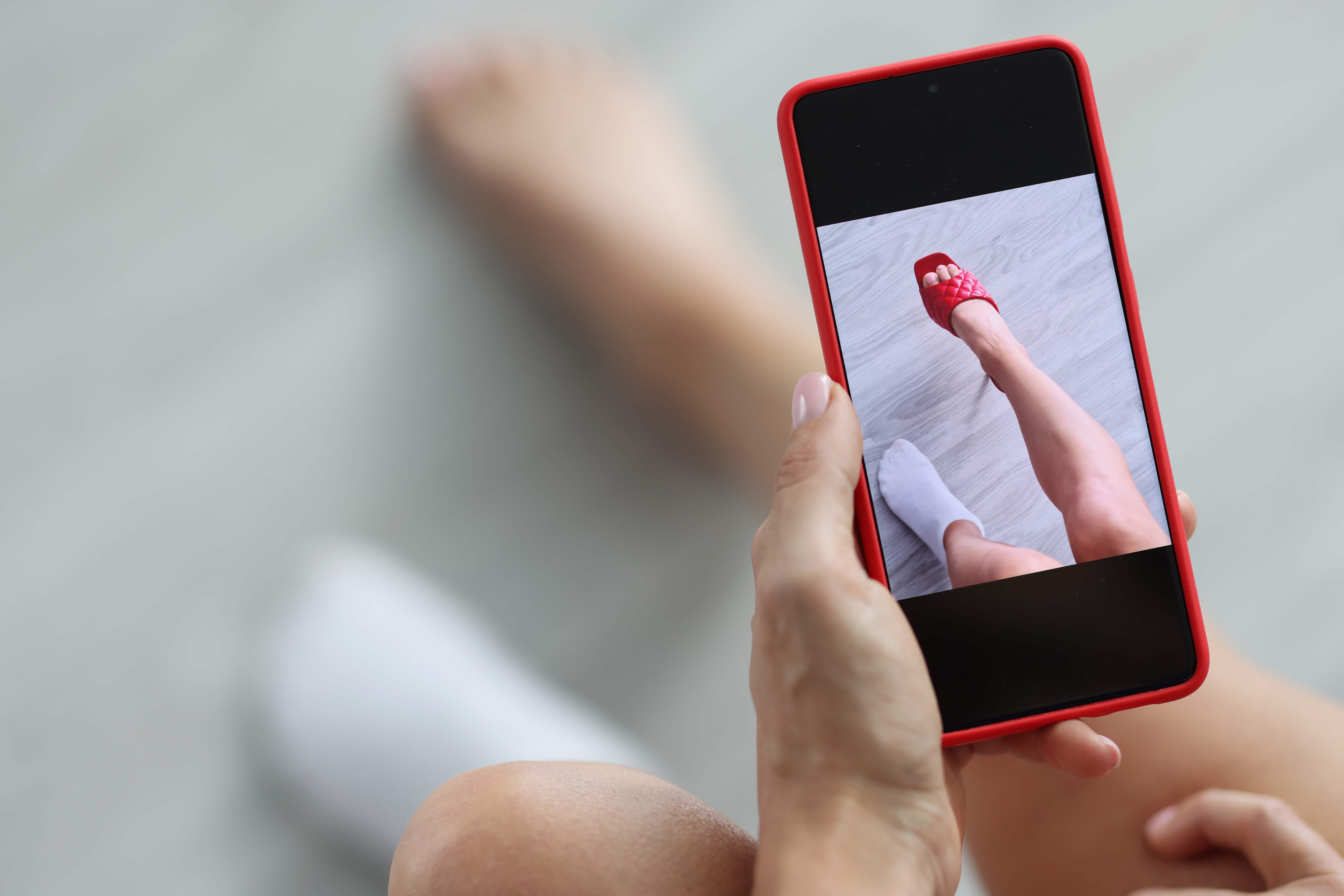 A woman trying on a shoe virtually via augmented reality on her phone