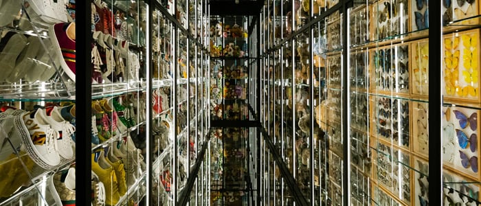A long hallway lined with shelves displaying a variety of shoes in the Gucci Garden