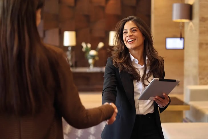 women handshaking in a hotel lobby