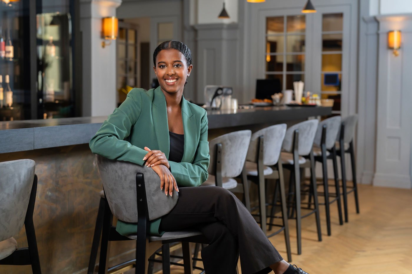 EHL Hotel School Passugg female student sitting at the bar smiling